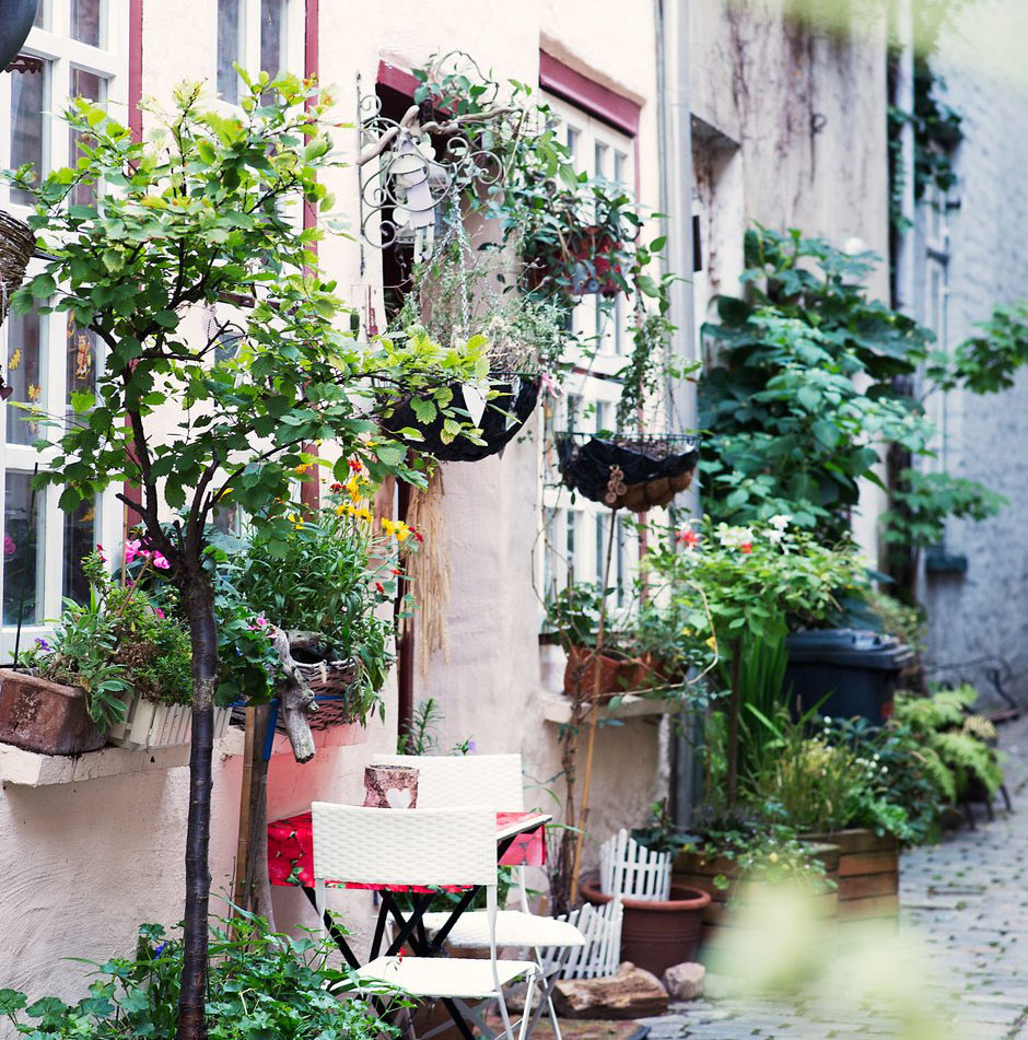 Lübecker Altstadt Ein Haus in der Lübecker Altstadt. Davor Blumentöpfe und eine Ampel sowie ein Tisch mit zwei Stühlen zum Verweilen.